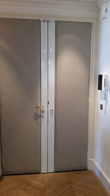 Cette double porte d'entrée est gainée d'un simili-cuir gris en finition invisible.
